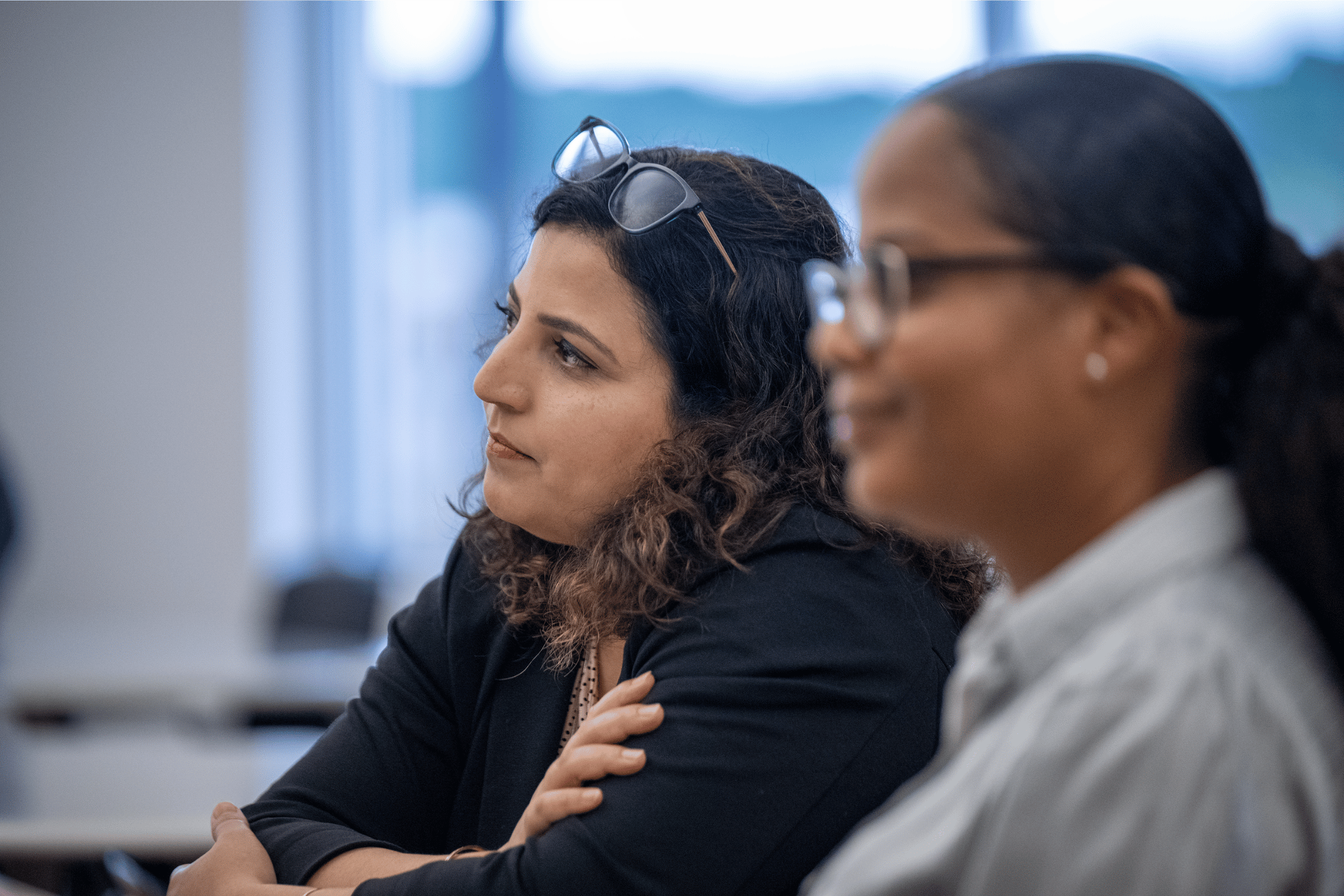 two women listening to speaker